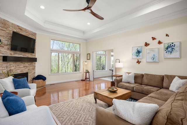 58651 Glacier Club Dr, Washington, MI 48094 - living area featuring ceiling fan, crown molding, a raised ceiling, wood finished floors, and a stone fireplace