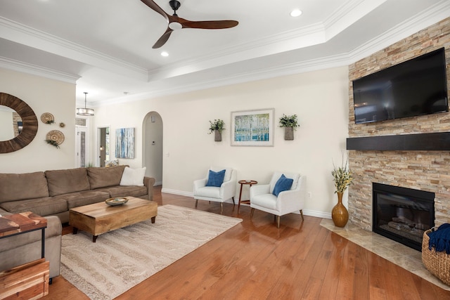 58651 Glacier Club Dr, Washington, MI 48094 - living room featuring a tray ceiling, a ceiling fan, arched walkways, wood-type flooring, and crown molding