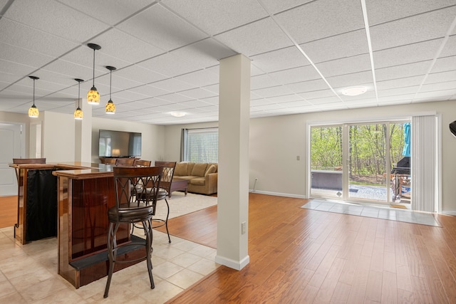 58651 Glacier Club Dr, Washington, MI 48094 - indoor bar featuring a paneled ceiling, light wood-style flooring, baseboards, and decorative light fixtures