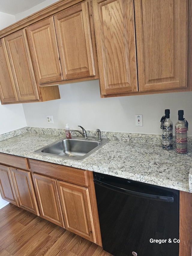 kitchen with dishwasher, a sink, and light countertops
