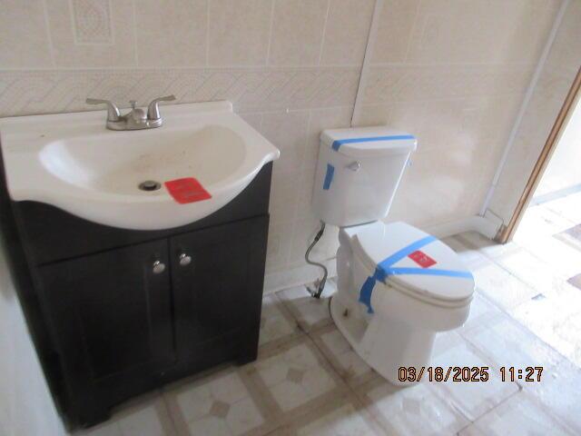 34637 76th St, Covert, MI 49043 - bathroom with vanity, toilet, and tile walls