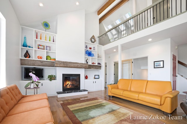 12250 Knoper Ct, Allendale, MI 49401 - living room with hardwood / wood-style flooring, a glass covered fireplace, high vaulted ceiling, and recessed lighting