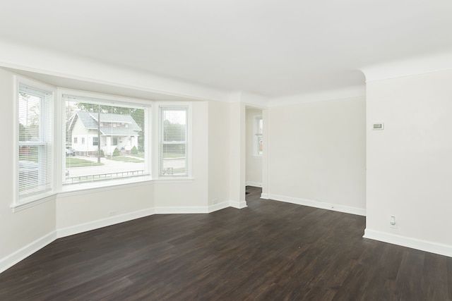 spare room with dark wood-style floors and baseboards