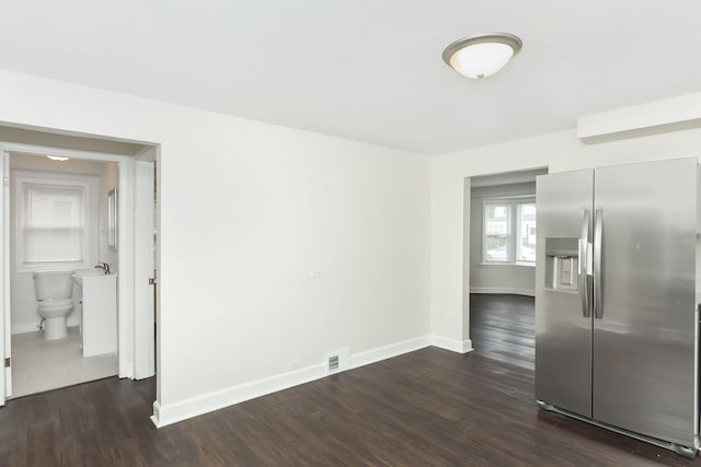 unfurnished dining area featuring baseboards and dark wood-type flooring