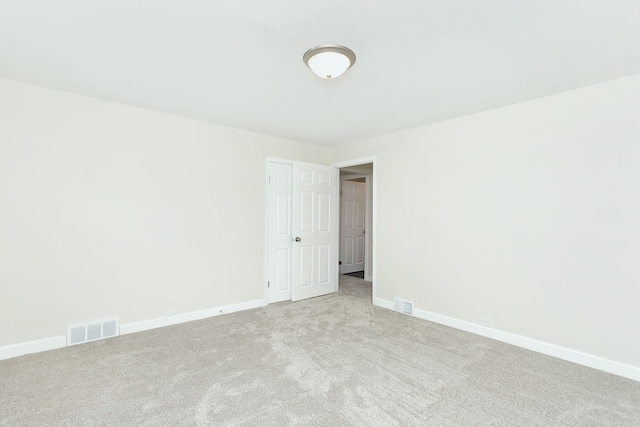 carpeted spare room featuring baseboards