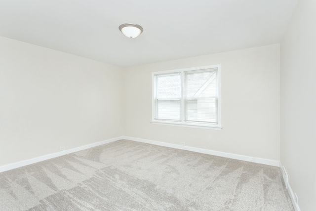 carpeted empty room with baseboards