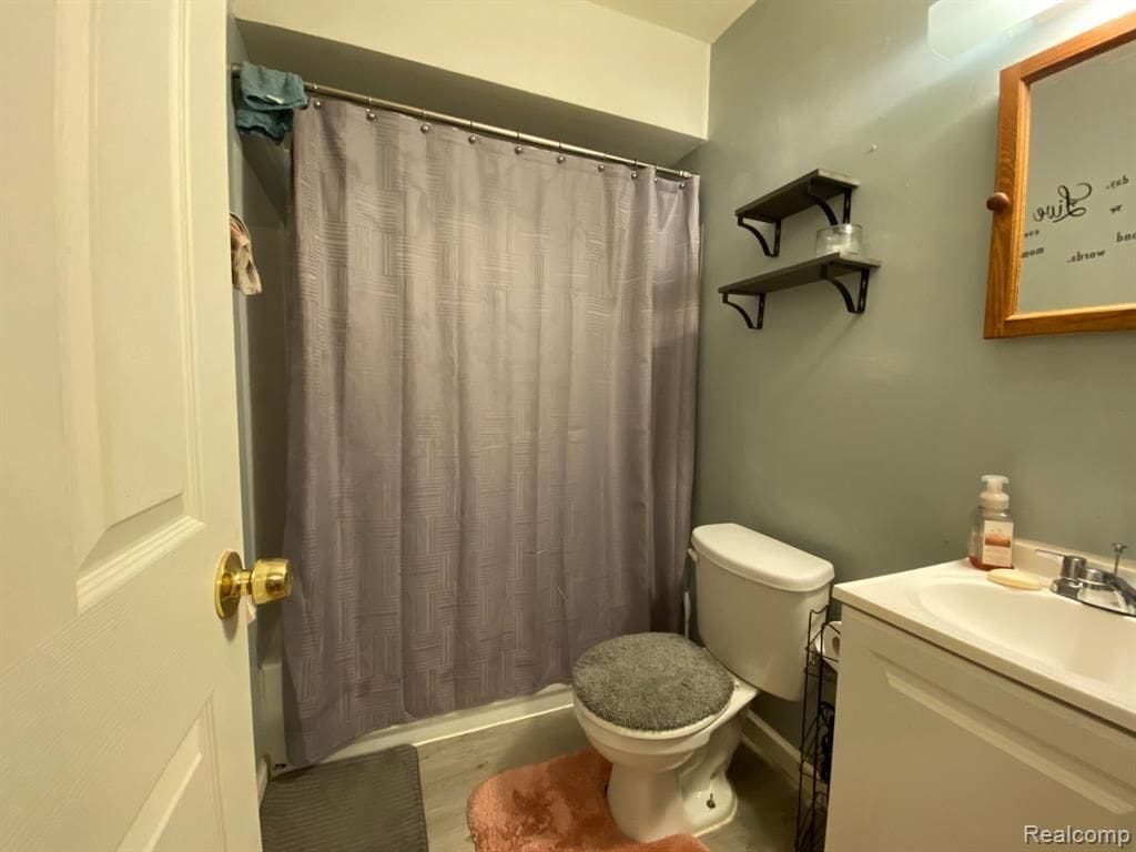 11107 Hudson Ave, Warren, MI 48089 - bathroom featuring toilet, a shower with curtain, and vanity