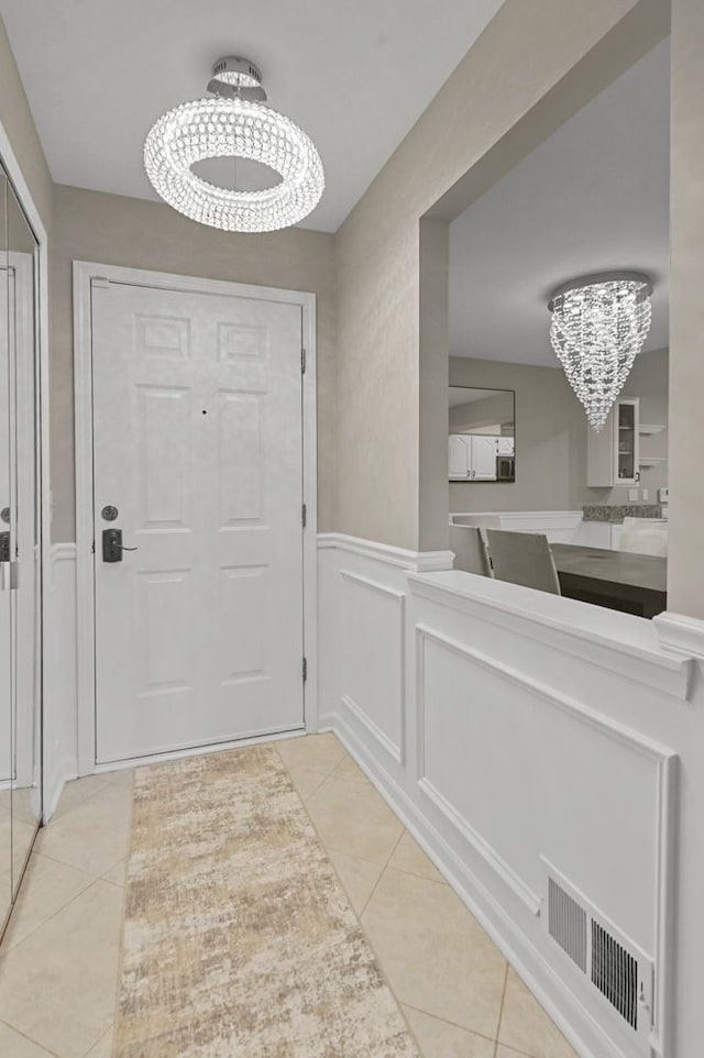 48775 Windmill Cir W, Macomb, MI 48044 - doorway with a chandelier, tile patterned flooring, wainscoting, and a decorative wall