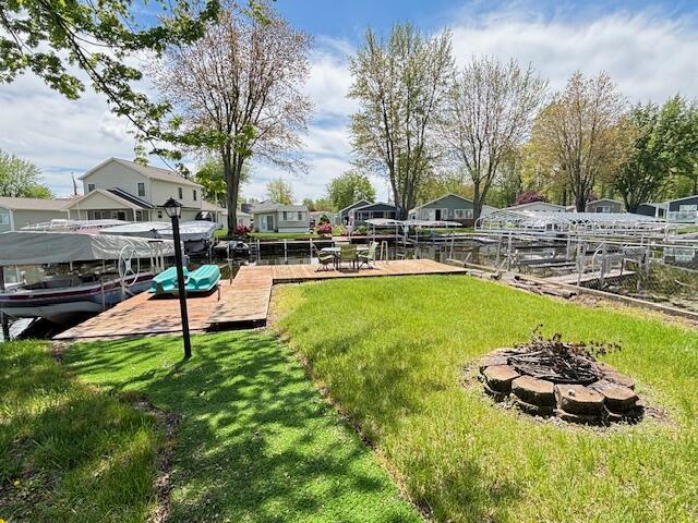 481 Maple Ln, Coldwater, MI 49036 - view of green lawn with a fire pit, a dock, and a residential view