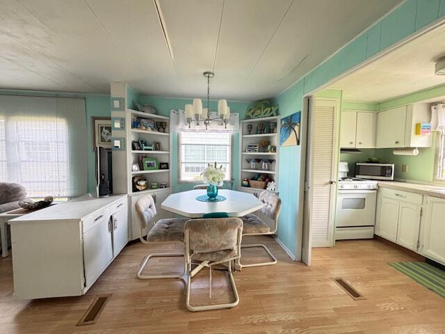 481 Maple Ln, Coldwater, MI 49036 - kitchen with white range with gas cooktop, stainless steel microwave, light wood-style floors, and open shelves