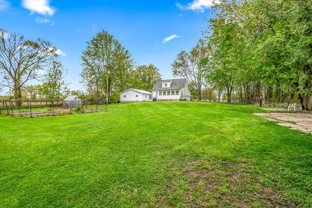 465 Ridge Rd, Quincy, MI 49082 - view of grassy yard with a greenhouse and an outbuilding