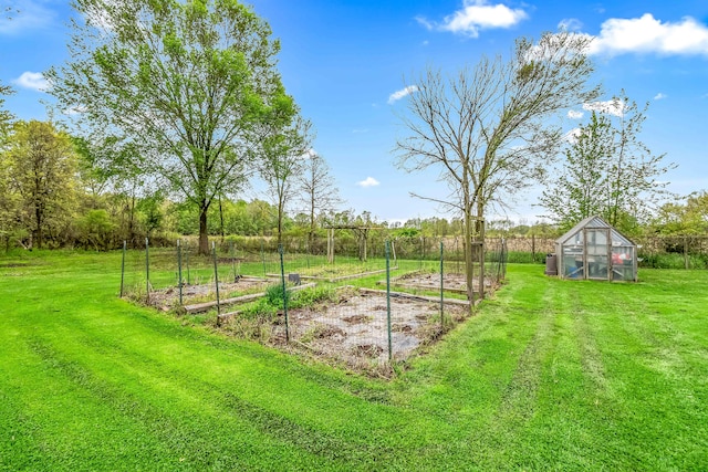 465 Ridge Rd, Quincy, MI 49082 - view of green lawn featuring a greenhouse, a vegetable garden, and an outdoor structure