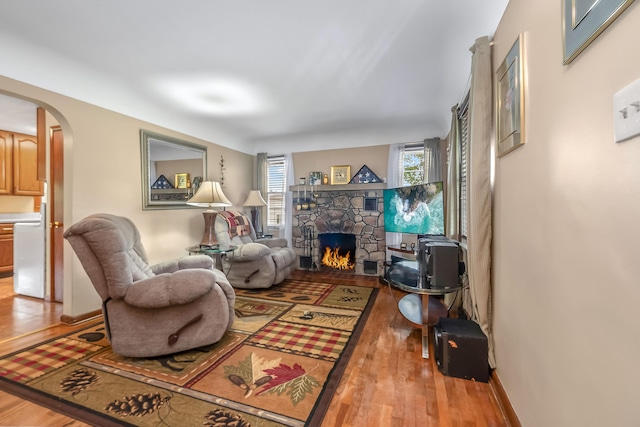 465 Ridge Rd, Quincy, MI 49082 - living area featuring arched walkways, a stone fireplace, and wood finished floors