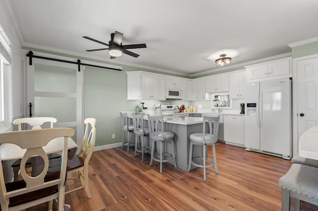 4150 Ridge Rd Unit 21And 22, Stevensville, MI 49127 - kitchen with white appliances, a ceiling fan, a kitchen breakfast bar, a barn door, and crown molding