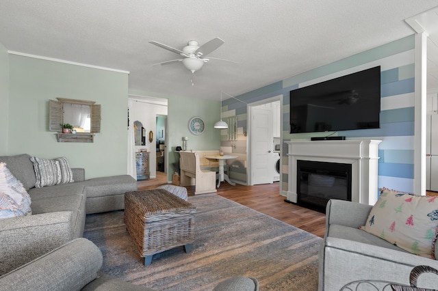 4150 Ridge Rd Unit 21And 22, Stevensville, MI 49127 - living room featuring a ceiling fan, wood finished floors, estacked washer and dryer, and a glass covered fireplace