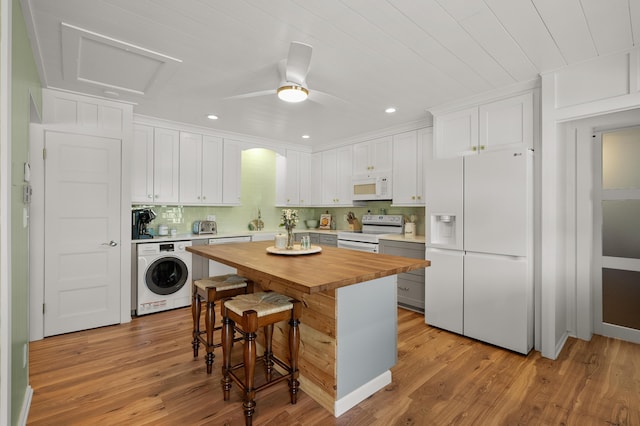 4150 Ridge Rd Unit 21And 22, Stevensville, MI 49127 - kitchen featuring white appliances, washer / dryer, butcher block countertops, a kitchen bar, and white cabinetry