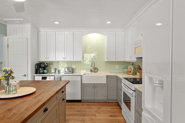 4150 Ridge Rd Unit 21And 22, Stevensville, MI 49127 - kitchen featuring white appliances, wood counters, a sink, light wood-style floors, and backsplash