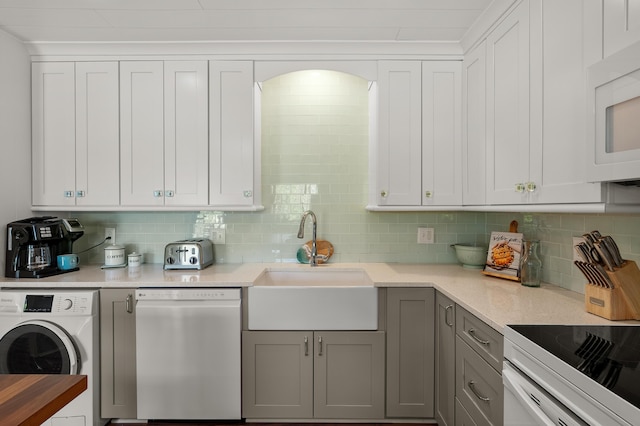 4150 Ridge Rd Unit 21And 22, Stevensville, MI 49127 - kitchen featuring dishwashing machine, washer / clothes dryer, white microwave, tasteful backsplash, and a sink