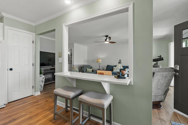 4150 Ridge Rd Unit 22, Stevensville, MI 49127 - kitchen with a textured ceiling, a breakfast bar, tile countertops, wood finished floors, and crown molding