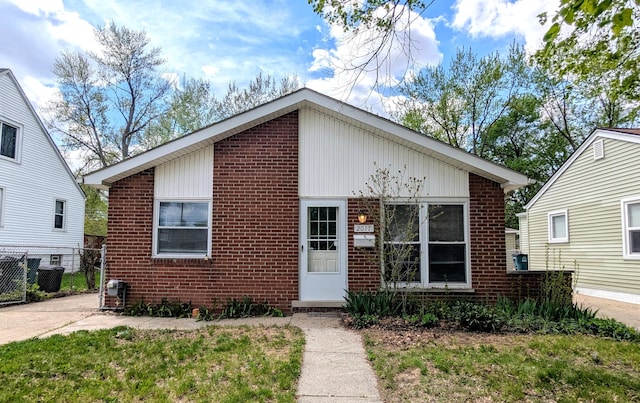 view of front of house with brick siding and fence
