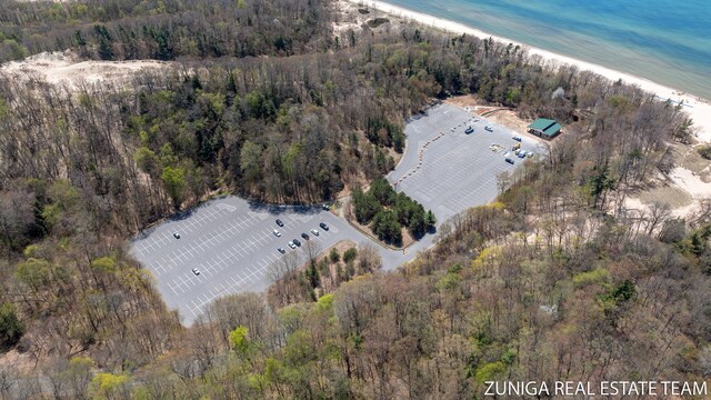 view of property location with a heavily wooded area and expansive coastline