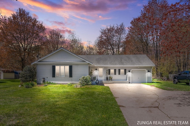 ranch-style house featuring concrete driveway, an attached garage, a yard, and a shingled roof