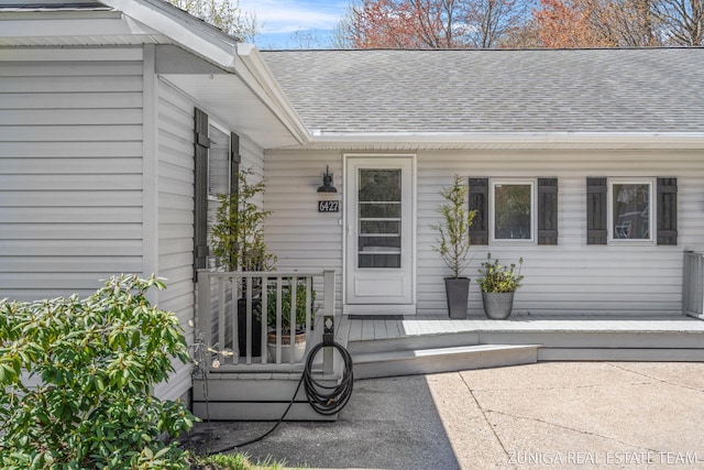 property entrance featuring roof with shingles