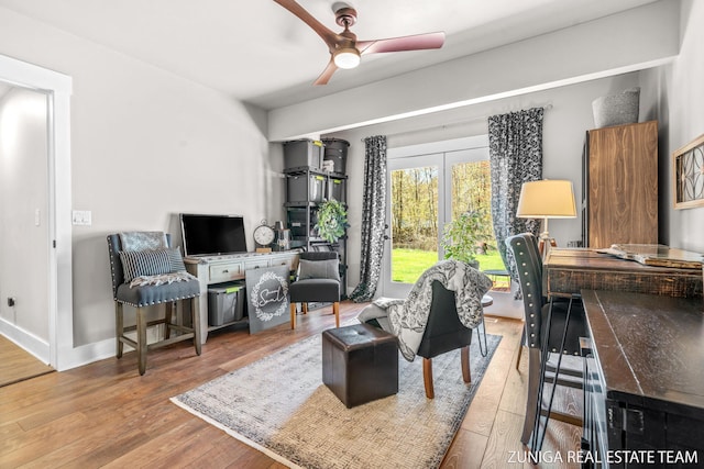 sitting room featuring wood finished floors, a ceiling fan, and baseboards