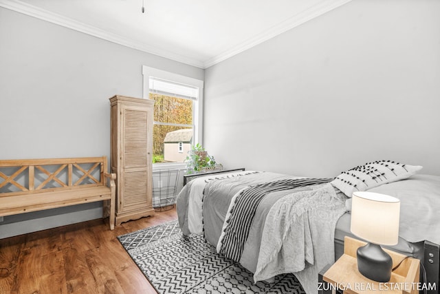 bedroom featuring wood finished floors and ornamental molding