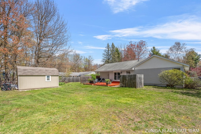 view of yard featuring a wooden deck, an outdoor structure, and a storage shed