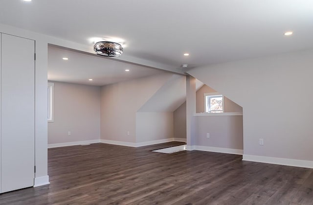 additional living space with dark wood finished floors, recessed lighting, baseboards, and lofted ceiling