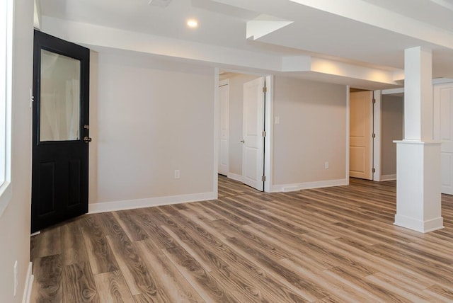 finished below grade area featuring wood finished floors, recessed lighting, and baseboards