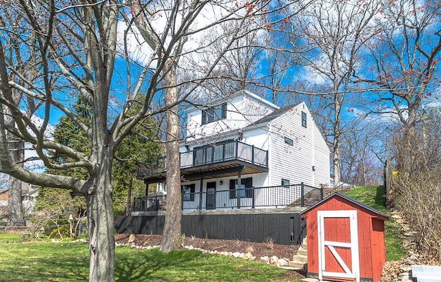 view of front of property with a shed, an outbuilding, a front yard, and a balcony