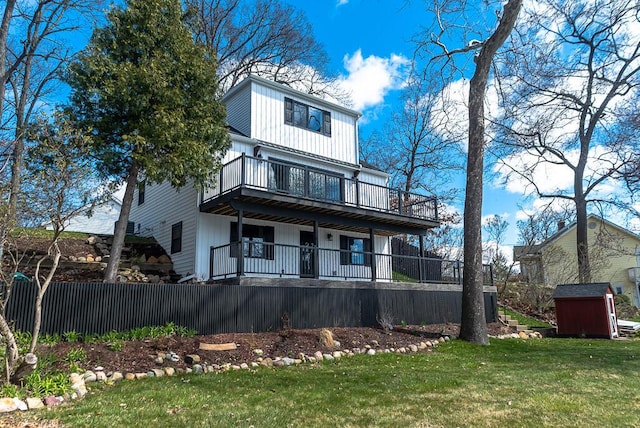 view of front facade with a storage unit, an outdoor structure, a wooden deck, and a balcony
