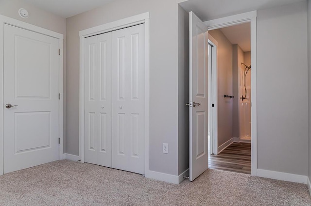 unfurnished bedroom featuring carpet floors, a closet, and baseboards