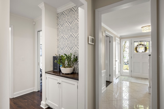 foyer entrance with ornamental molding and baseboards