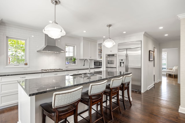 kitchen featuring a sink, built in appliances, wall chimney exhaust hood, open shelves, and ornamental molding