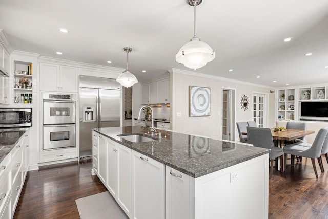 kitchen featuring appliances with stainless steel finishes, a sink, dark wood-style floors, a kitchen island with sink, and recessed lighting