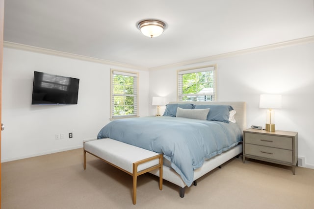 bedroom with light carpet, ornamental molding, and baseboards