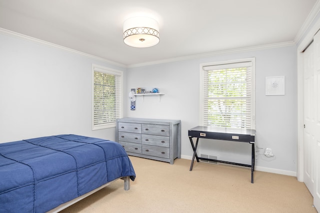 carpeted bedroom featuring ornamental molding, baseboards, and a closet