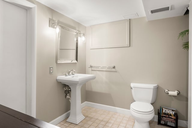 half bathroom with toilet and baseboards