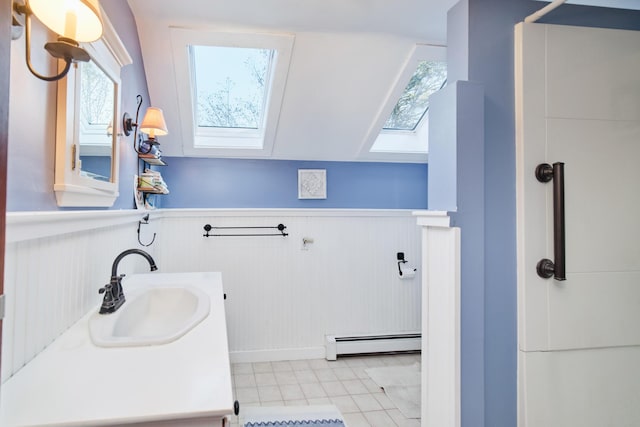 1621 W Beyer Rd, Ludington, MI 49431 - full bathroom with a baseboard heating unit, a skylight, tile patterned flooring, wainscoting, and vanity
