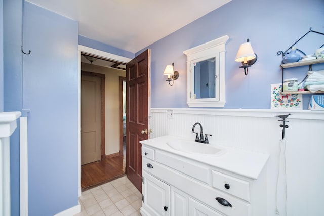 1621 W Beyer Rd, Ludington, MI 49431 - bathroom featuring a wainscoted wall, vanity, and tile patterned flooring