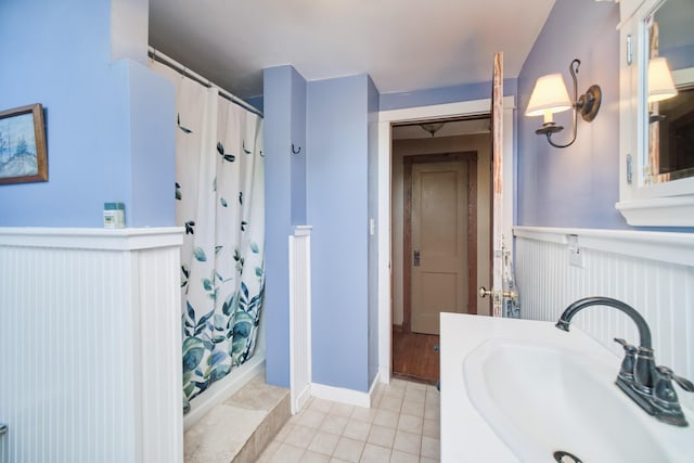 1621 W Beyer Rd, Ludington, MI 49431 - full bath featuring a sink, wainscoting, a shower with curtain, and tile patterned floors