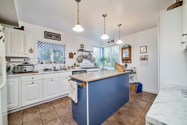 1621 W Beyer Rd, Ludington, MI 49431 - kitchen with plenty of natural light, a sink, white cabinets, and pendant lighting