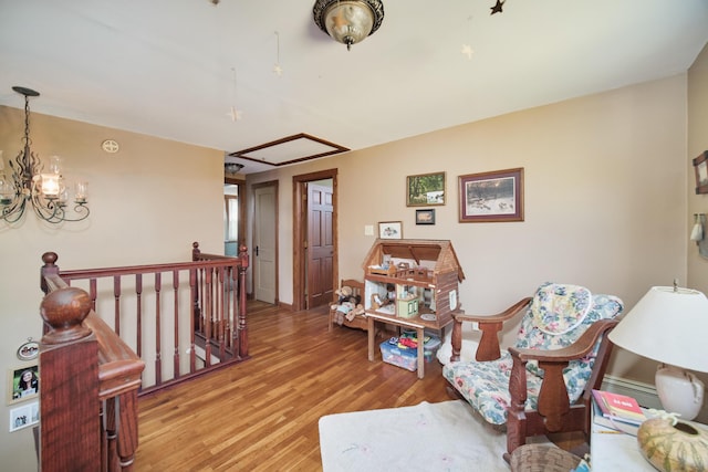 1621 W Beyer Rd, Ludington, MI 49431 - sitting room with an upstairs landing, light wood-type flooring, a chandelier, and attic access