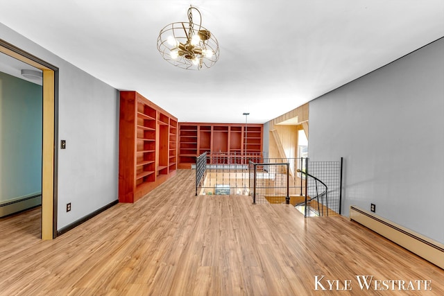 405 S 1st St, Edmore, MI 48829 - unfurnished living room with a baseboard heating unit, a chandelier, wood finished floors, and built in shelves