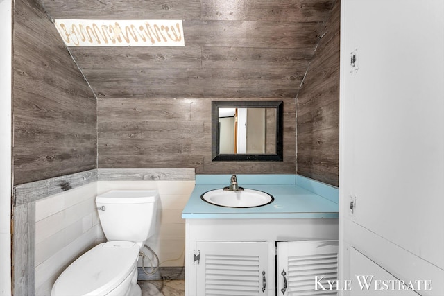 405 S 1st St, Edmore, MI 48829 - half bathroom featuring wooden walls, toilet, vanity, and lofted ceiling
