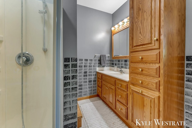 405 S 1st St, Edmore, MI 48829 - bathroom with a shower, vanity, tile walls, and tile patterned flooring
