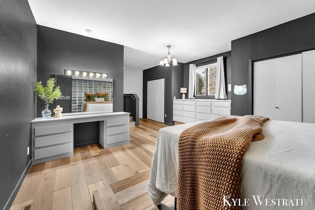 405 S 1st St, Edmore, MI 48829 - bedroom featuring light wood-type flooring, a chandelier, an office area, baseboards, and two closets